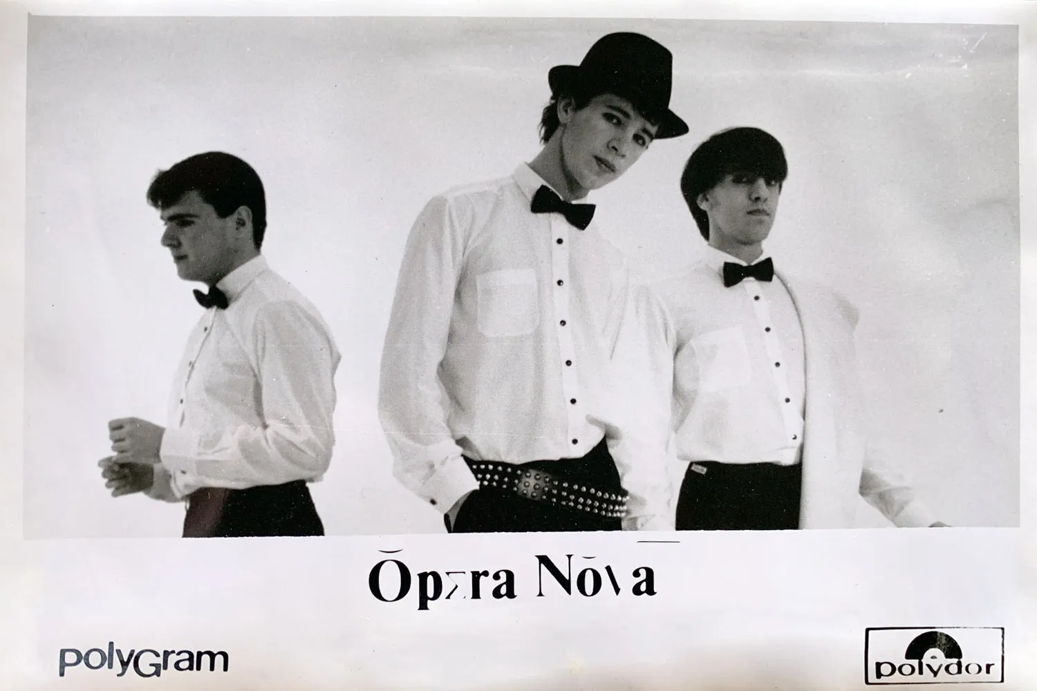 Fotografia promocional dos Ópera Nova: três músicos de camisa branca e laço, um deles de chapéu de coco, sobre fundo branco; logótipos Polygram e Polydor.