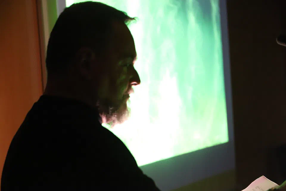 Backlit profile against the generative projection, during the performance